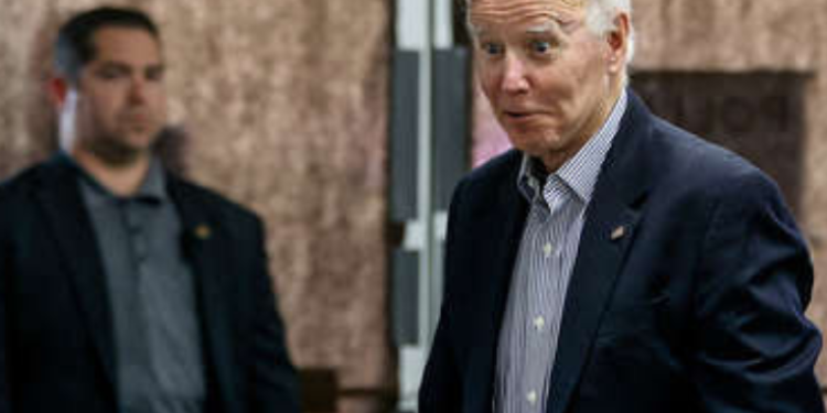 Biden pide ayuda a un voluntario durante su votación anticipada de medio mandato.