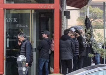 Decenas de personas hacen cola para retirar su dinero de un banco ante el aumento de la incertidumbre financiera en EE.UU.