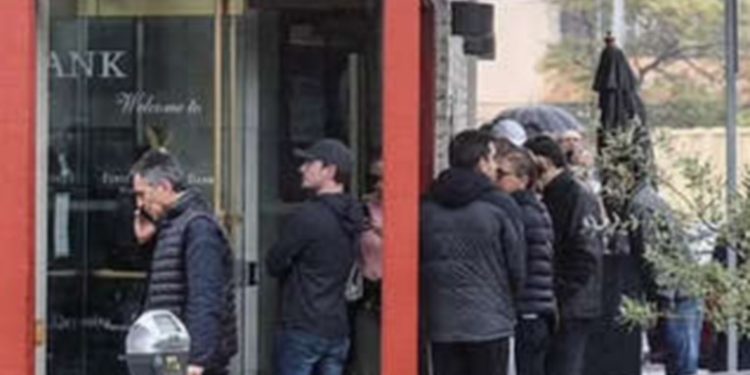 Decenas de personas hacen cola para retirar su dinero de un banco ante el aumento de la incertidumbre financiera en EE.UU.