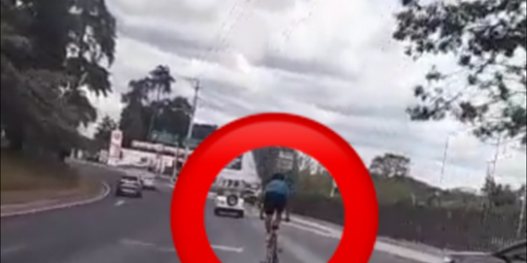 Graban a hombre manejando en la via parado en su bicicleta